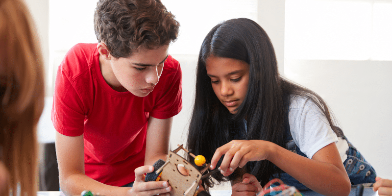 Female and Male student looking at robotics.